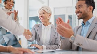 Handshake, partnership and business people clapping hands in celebration, congratulations or motivation. Collaboration, applause and senior woman shaking hands with company partner after success deal