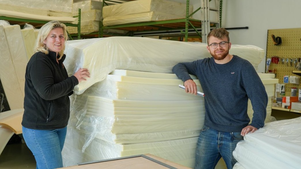 Katrin Hackl und Felix Hackl von der Eugen Bender GmbH in Nürnberg mit einem Stapel Schaumstoffe.