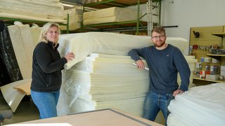 Katrin Hackl und Felix Hackl von der Eugen Bender GmbH in Nürnberg mit einem Stapel Schaumstoffe.