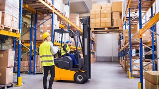 Young warehouse workers working together.