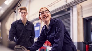 Male And Female Students Looking At Car Engine On Auto Mechanic Apprenticeship Course At College